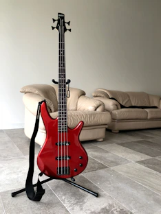 red electric guitar on black steel stand
