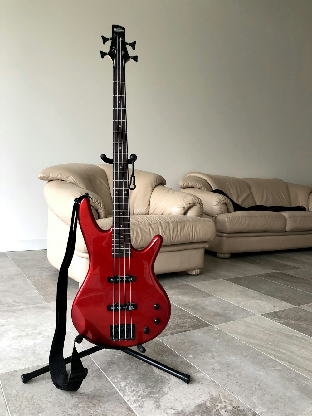 red electric guitar on black steel stand