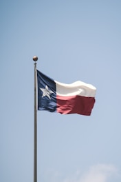 white and red flag on pole during daytime