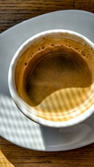 Coffee influencer showcasing a rich espresso shot in a sunlit café.