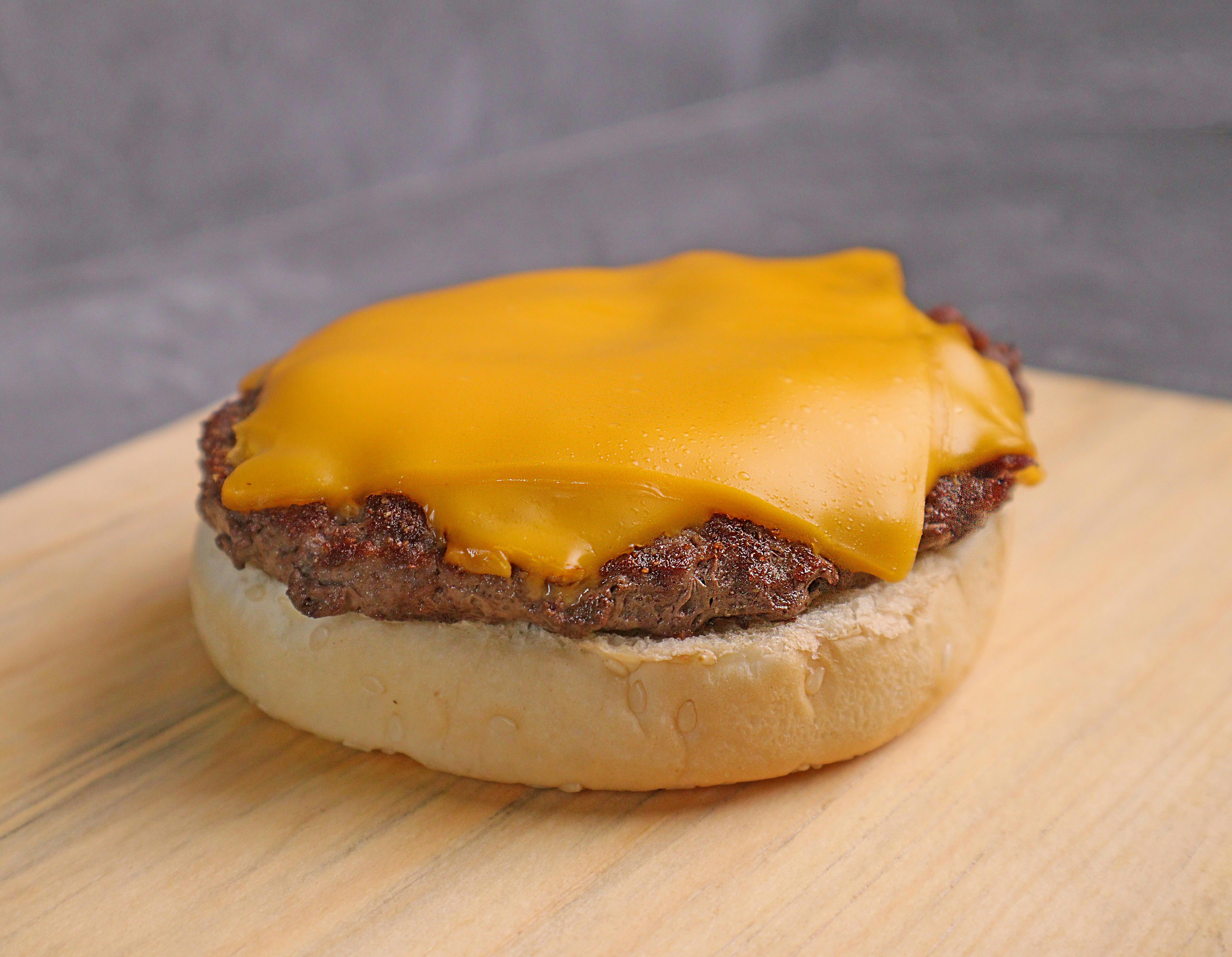 Hamburguesa con queso sobre mesa de madera marrón