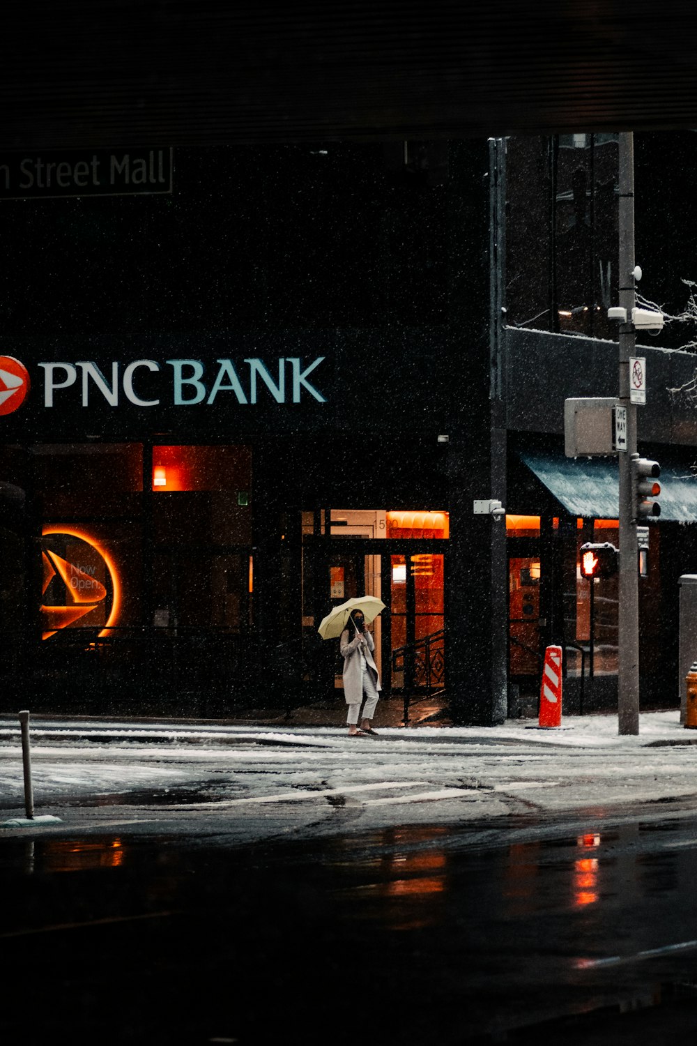 man in white coat walking on sidewalk during night time