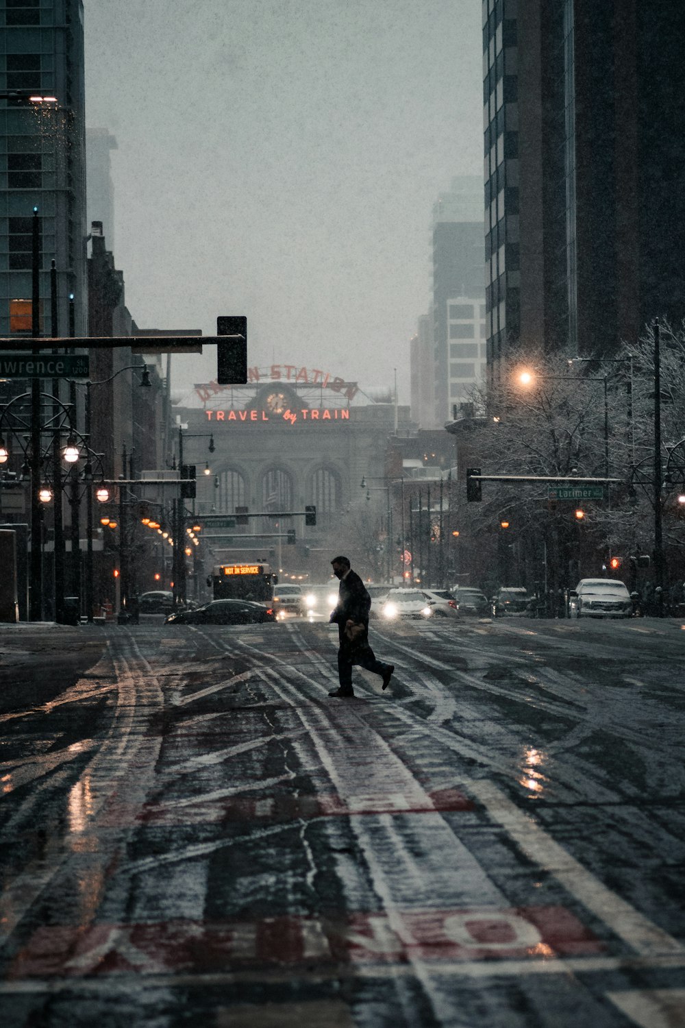 person in black jacket walking on pedestrian lane during daytime