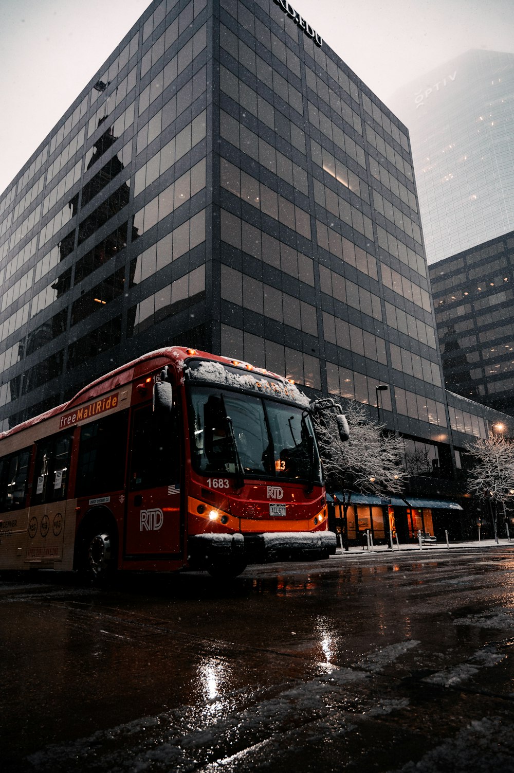 Bus rouge à impériale sur la route près d’un bâtiment pendant la journée