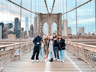 3 women standing on bridge during daytime