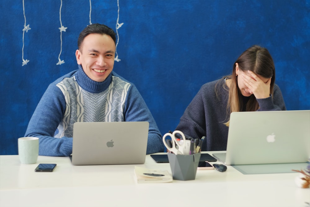 シルバーのMacBookを使用した灰色のセーターの女性