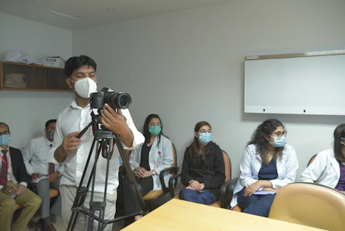 Thamer Almemony guiding a clinical team through a hands-on medical simulation session in a hospital training room.