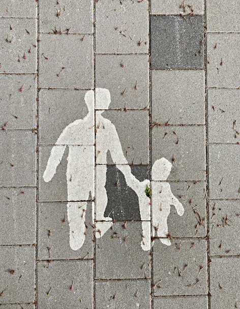 2 person walking on gray concrete pavement