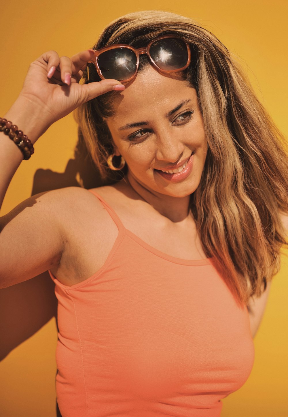 woman in orange tank top wearing black sunglasses