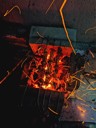 A vibrant shot of the outdoor Smokecraft stationary BBQ bar with meats cooking over glowing coals.