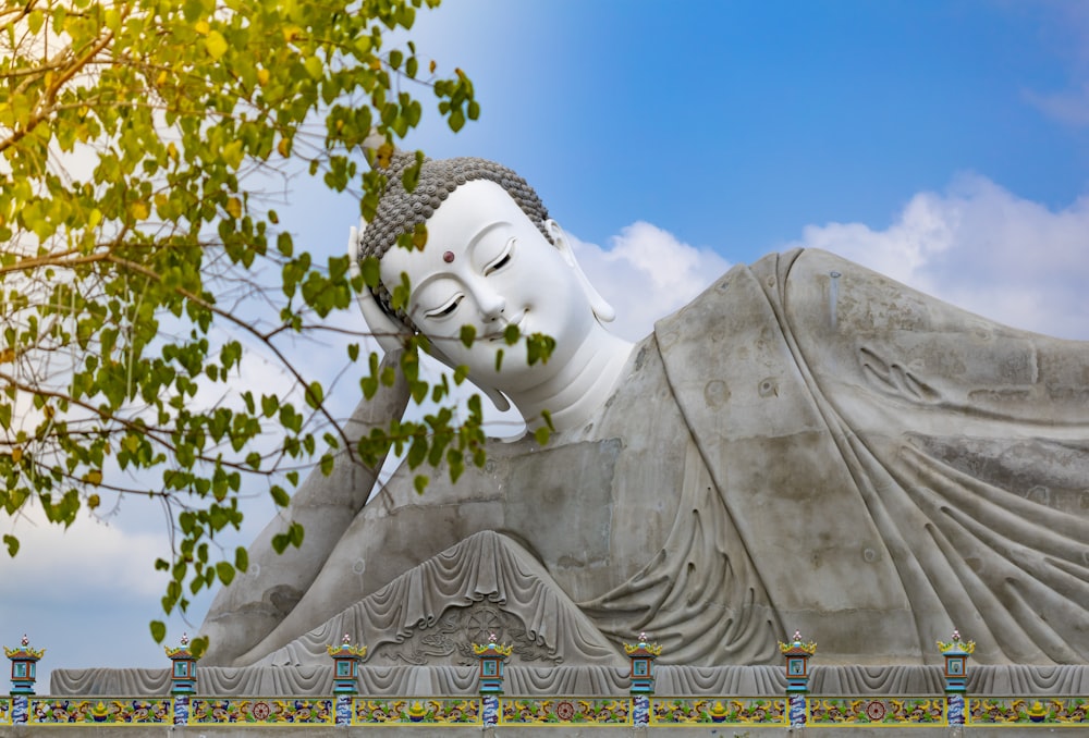 Estatua de hormigón blanco bajo el cielo azul durante el día