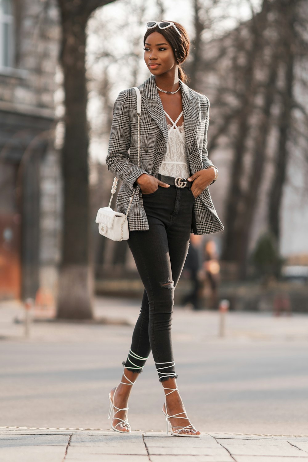 Mujer con blazer gris y pantalones negros sosteniendo una taza de cerámica blanca