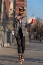 woman in gray blazer and black pants standing on road during daytime