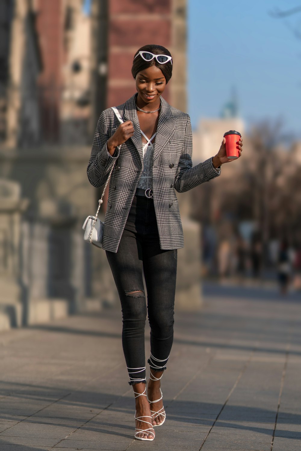 woman in gray blazer and black pants standing on road during daytime