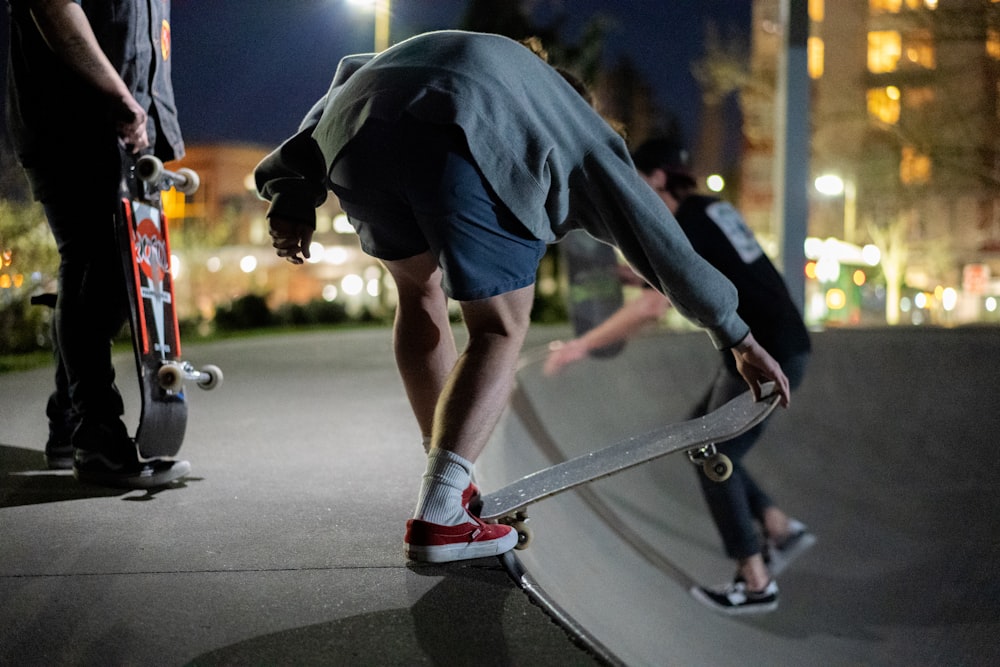 man in blue t-shirt and black pants riding skateboard during daytime