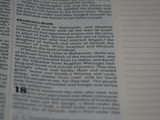A close-up view of a book page featuring a passage titled 'Absalom's death'. The text describes events involving David, Absalom, and other biblical figures. The right side of the image shows blank lines, possibly for notes.