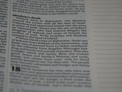 A close-up view of a book page featuring a passage titled 'Absalom's death'. The text describes events involving David, Absalom, and other biblical figures. The right side of the image shows blank lines, possibly for notes.