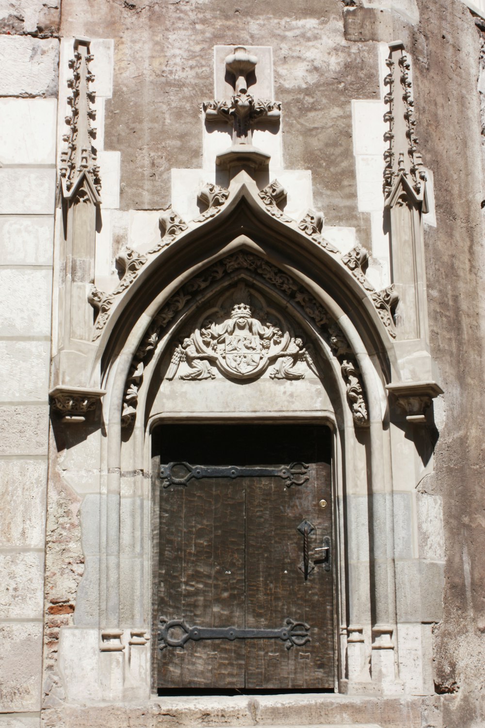 puerta de madera marrón sobre edificio de hormigón gris