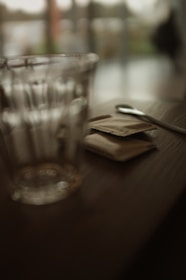 Close-up of a spoonful of white stevia sweetener crystals on a wooden table.