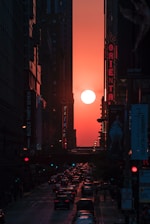 A vibrant city street at sunset with lively traffic and people using smartphones.