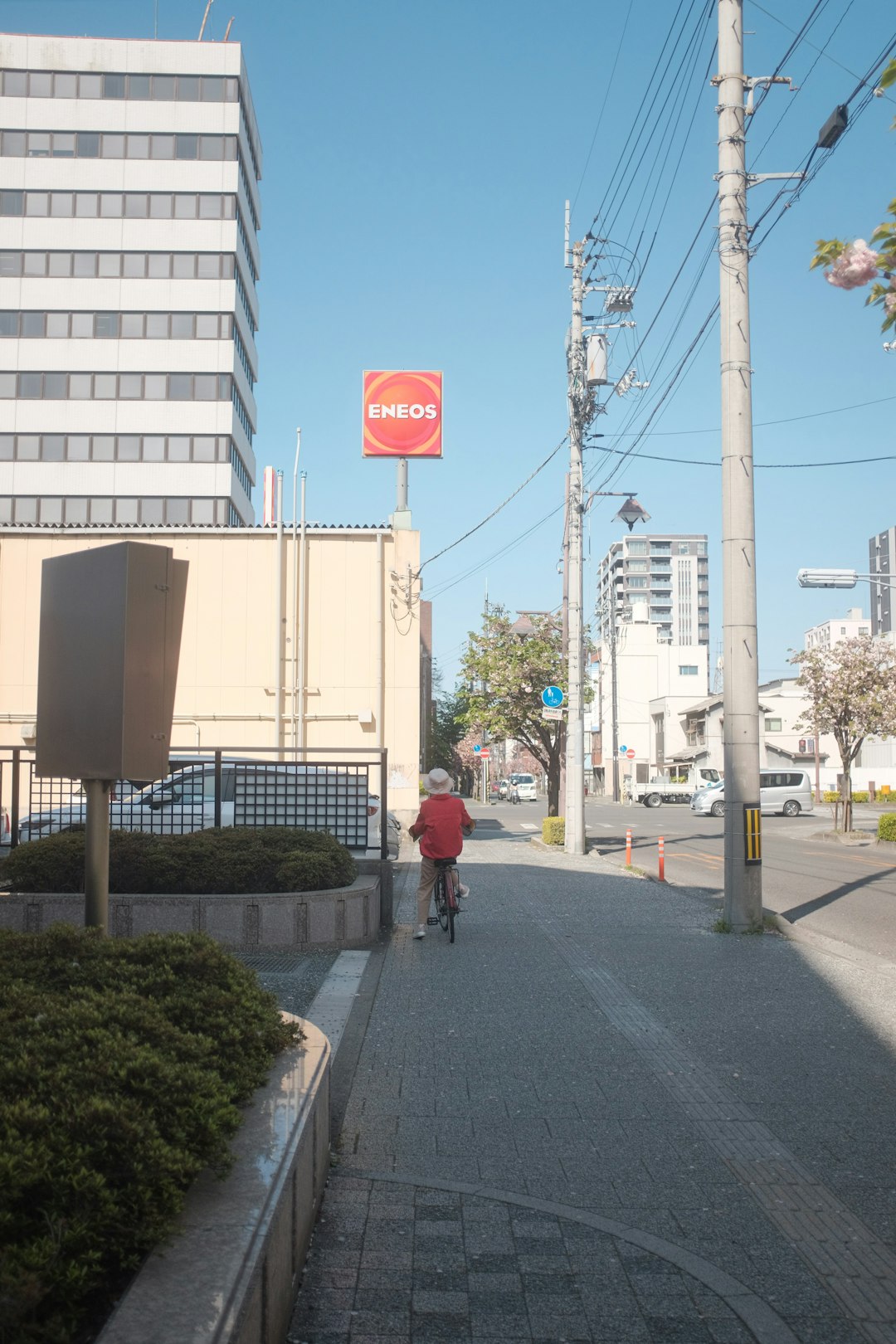 person in red jacket walking on sidewalk during daytime