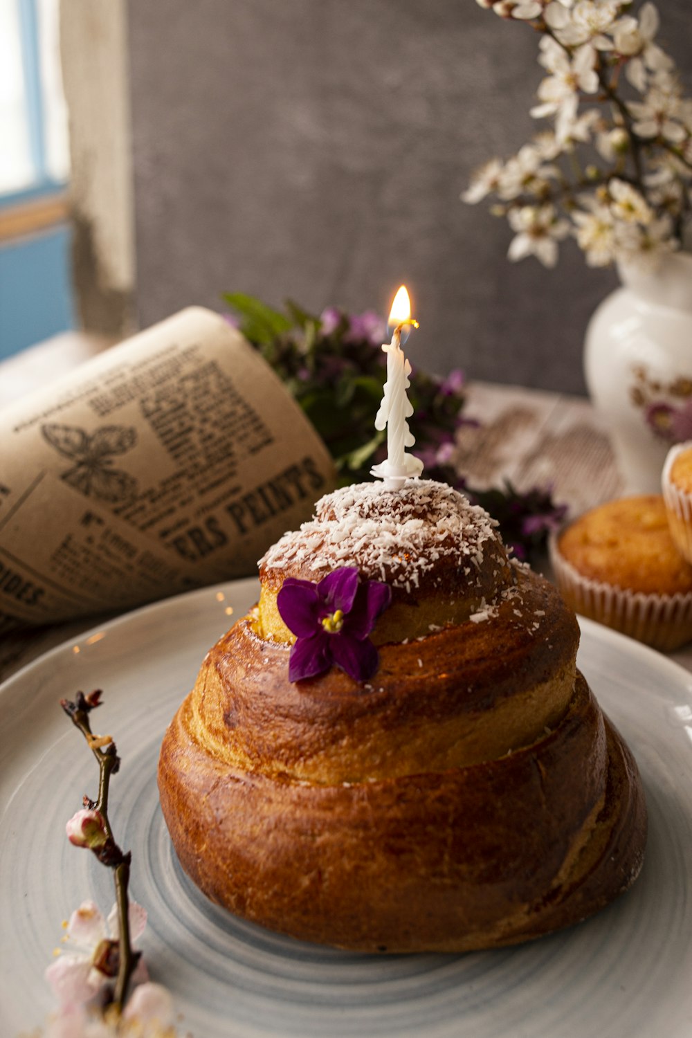 chocolate cake with lighted candles on white ceramic plate