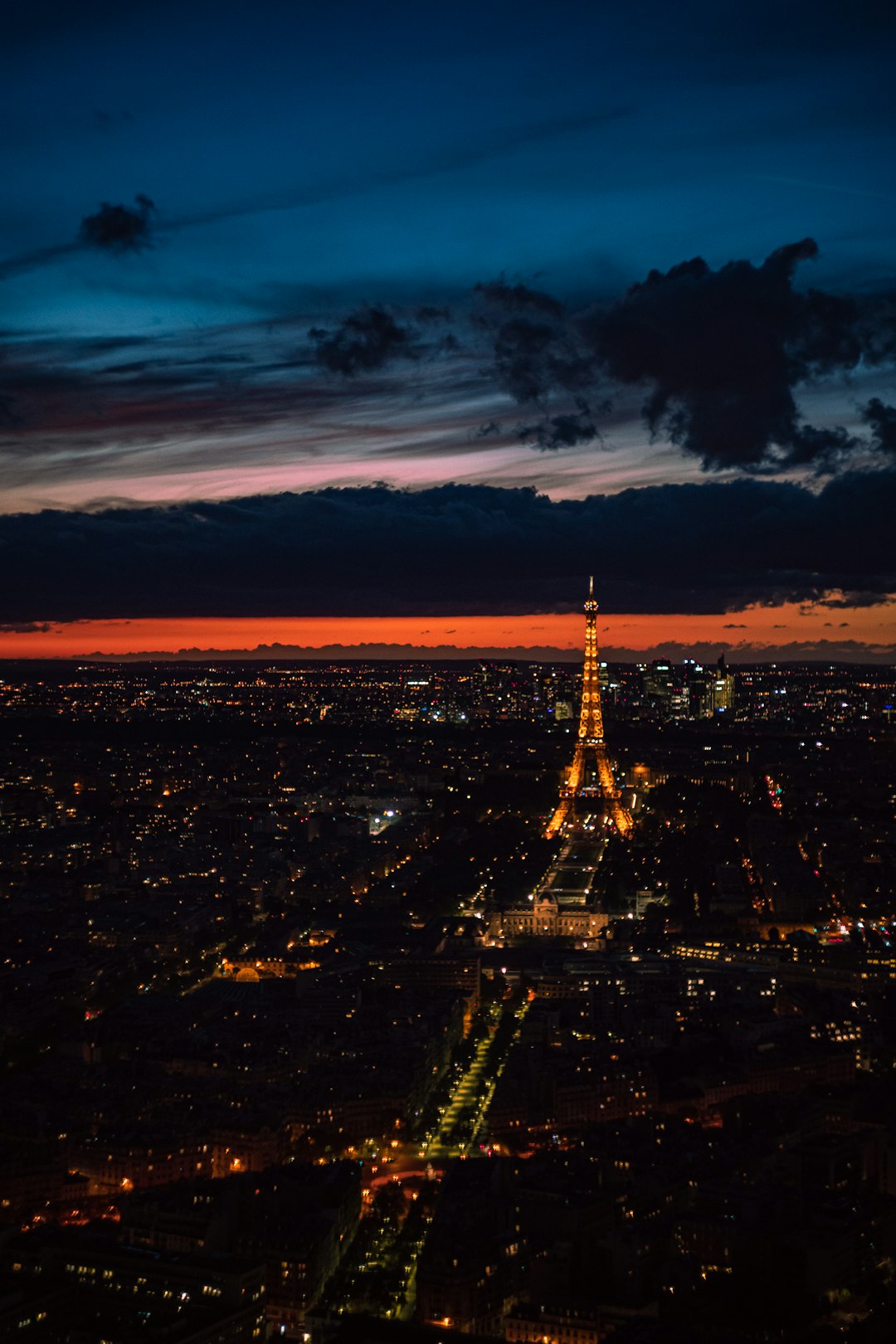 city skyline under cloudy sky during night time