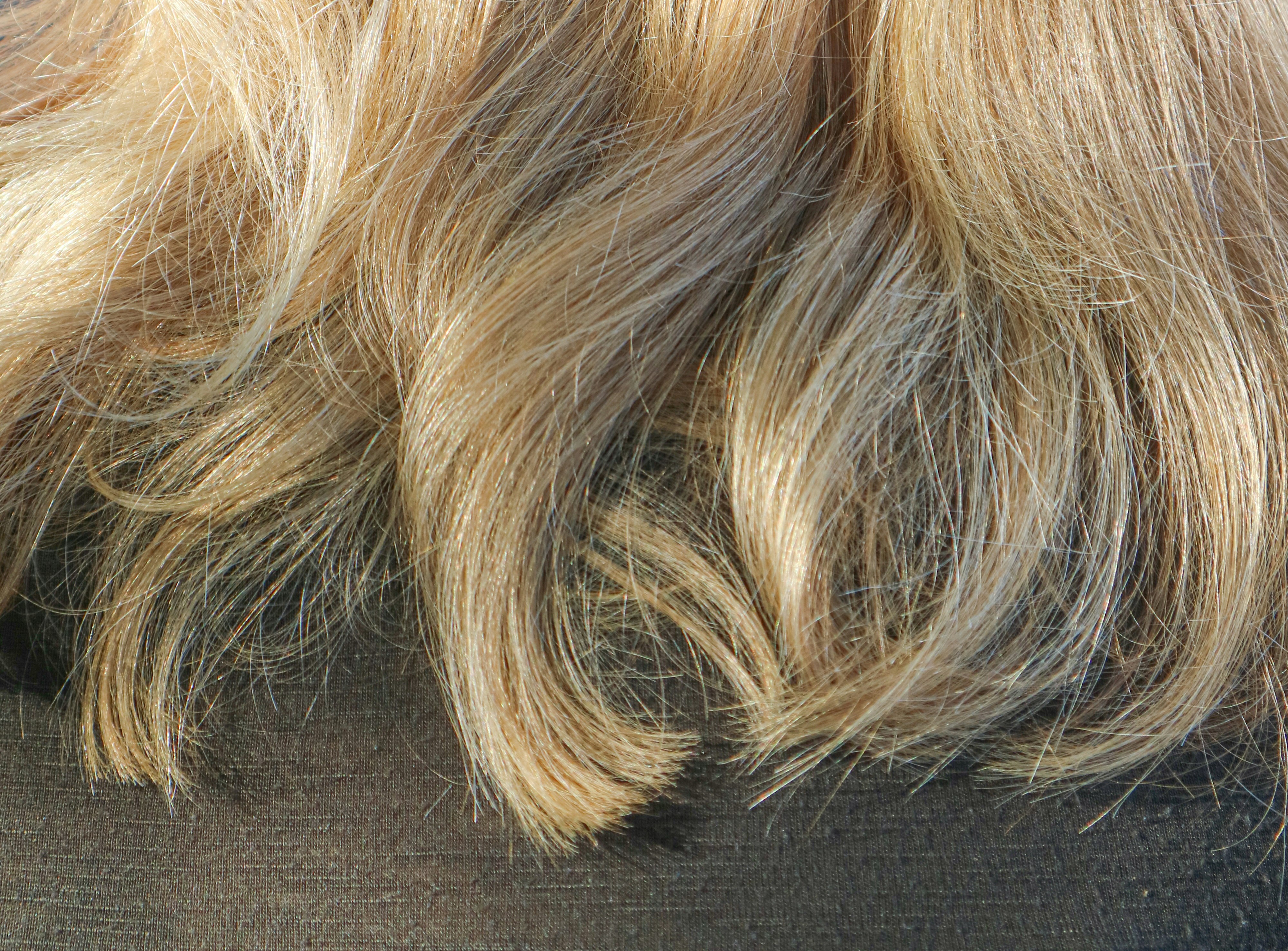 Close-up of wavy blonde hair showing texture enhanced by hand sewn wefts