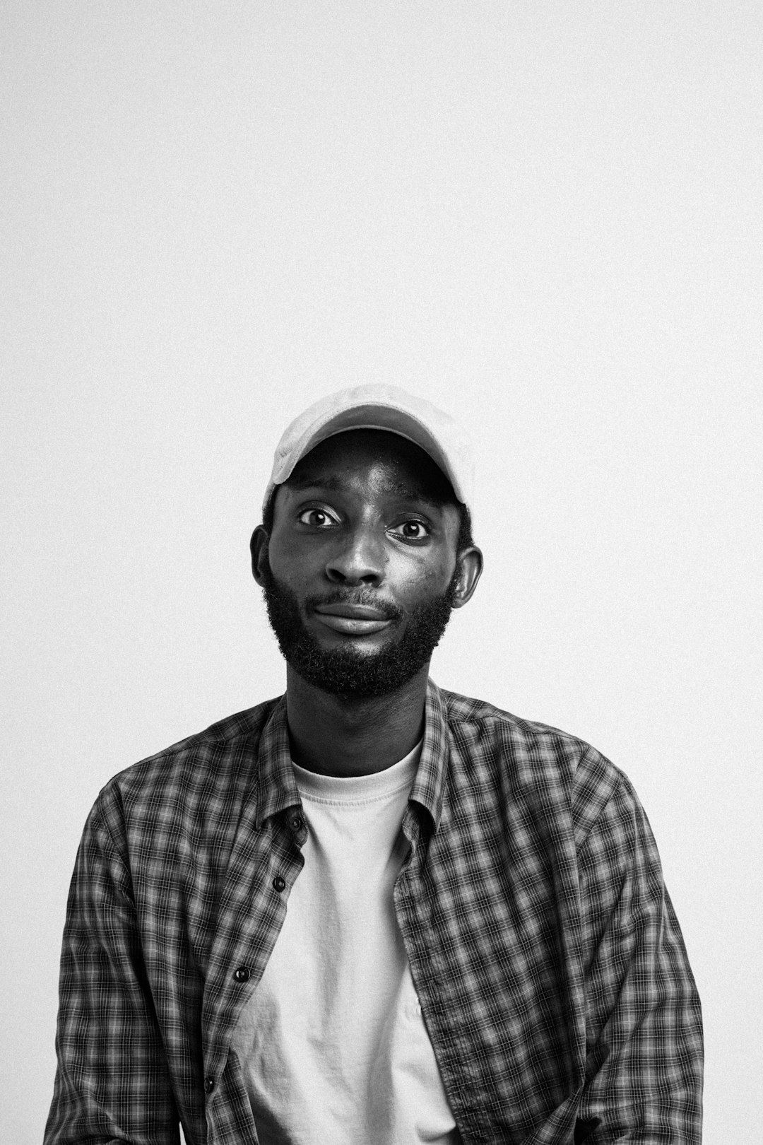 man in plaid shirt wearing white cap