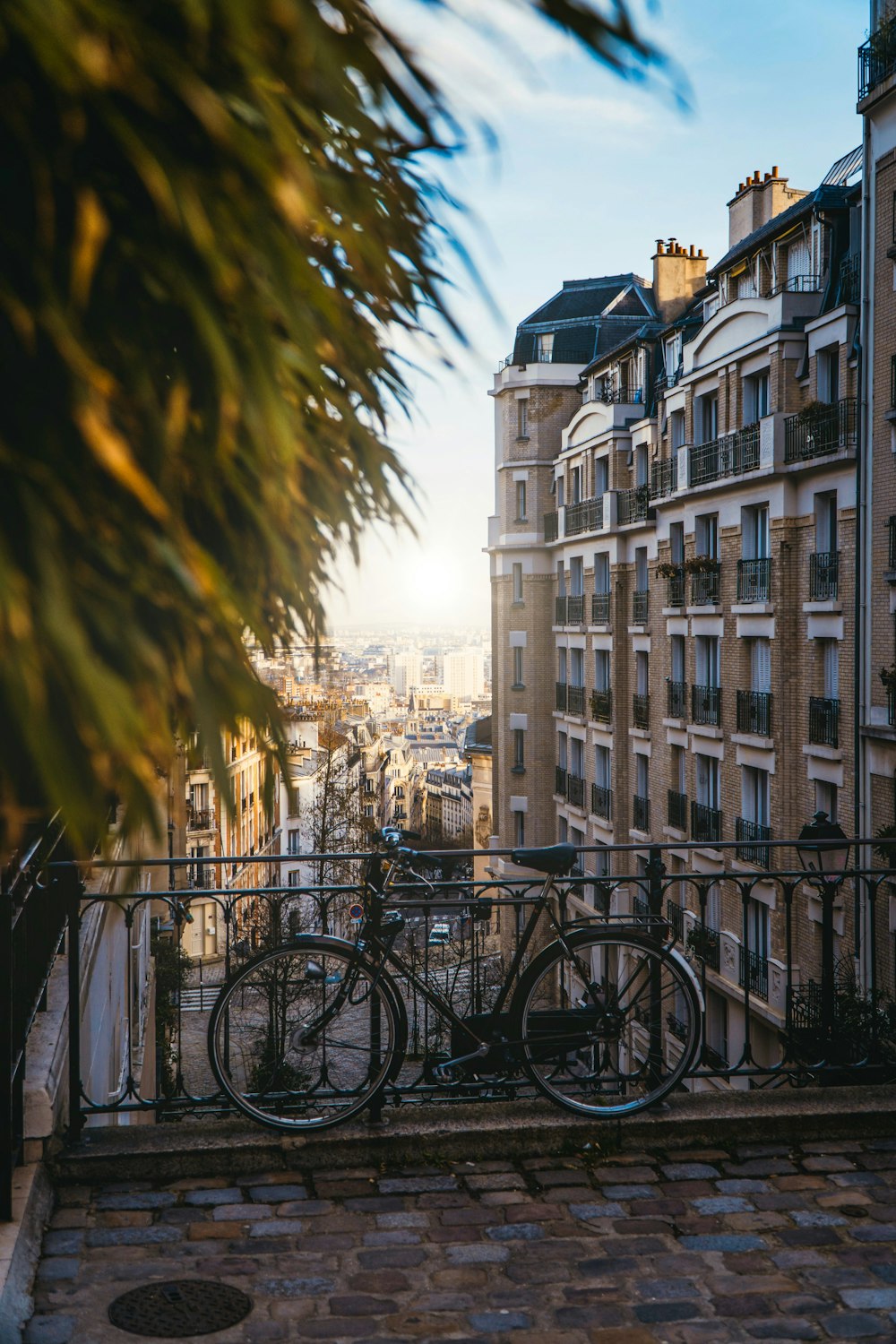 black bicycle parked beside black metal fence during daytime