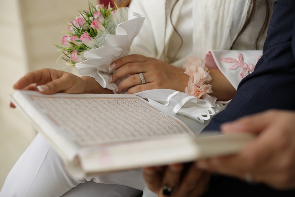 person in white dress shirt holding white book