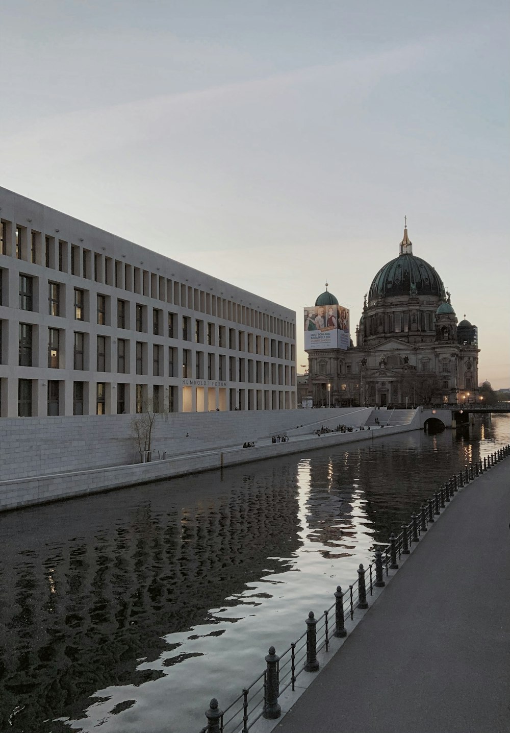 edificio in cemento bianco vicino a uno specchio d'acqua durante il giorno