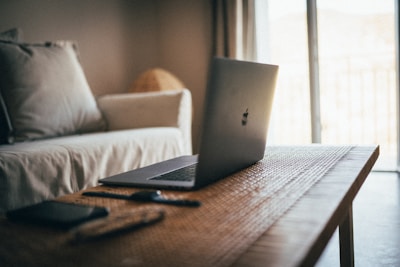 silver macbook on brown table