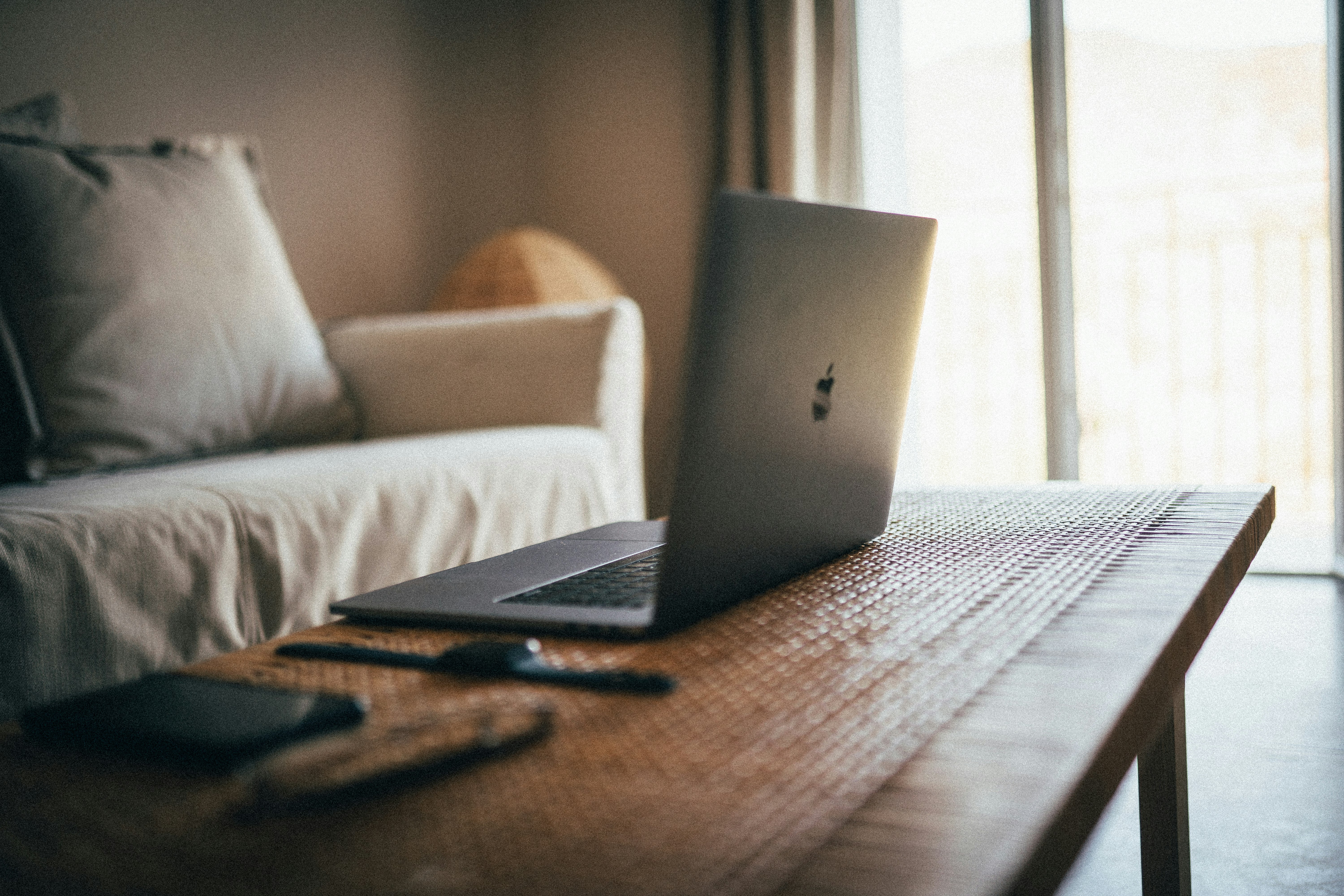 silver macbook on brown table