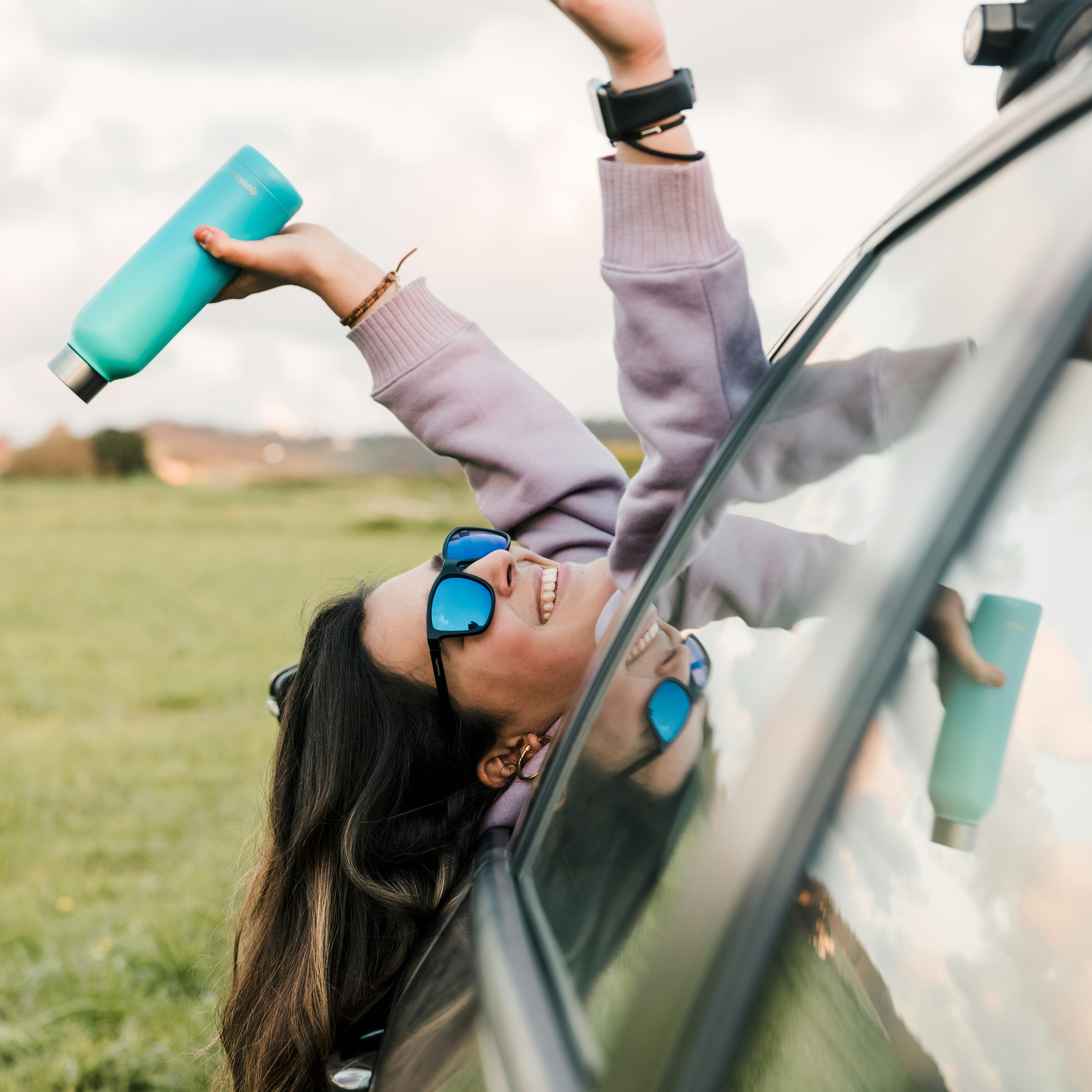 woman in white long sleeve shirt holding blue plastic cup