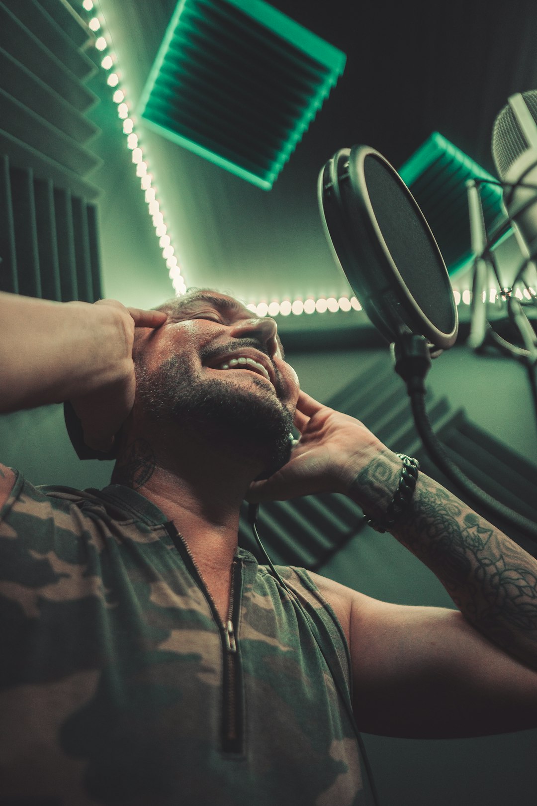 man in green and black camouflage button up shirt holding microphone