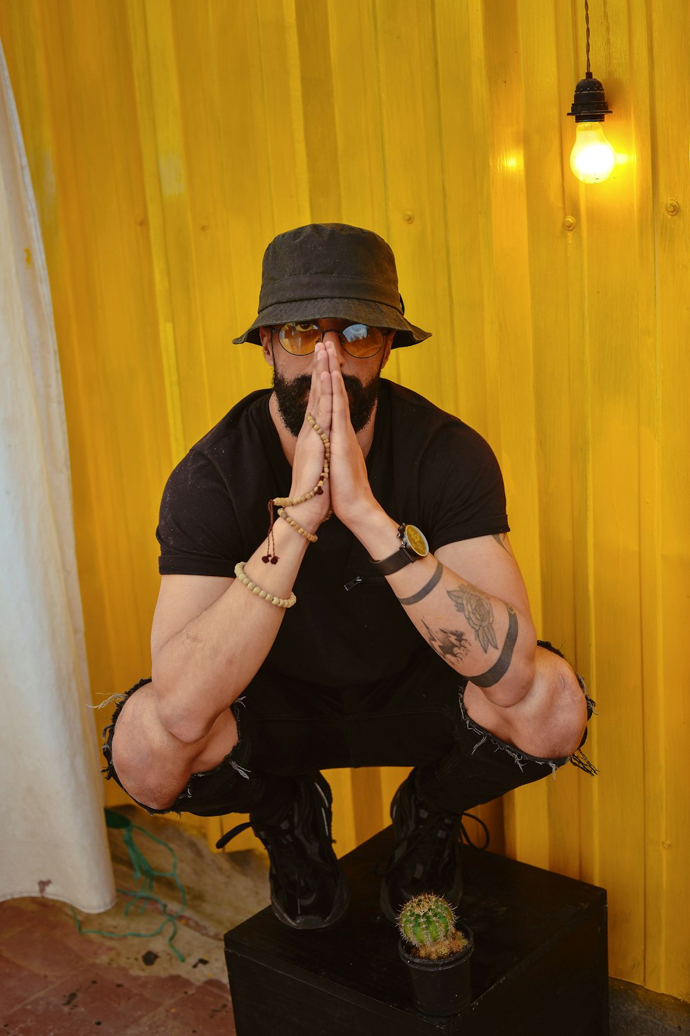 man in black t-shirt and black pants wearing black cap sitting on chair