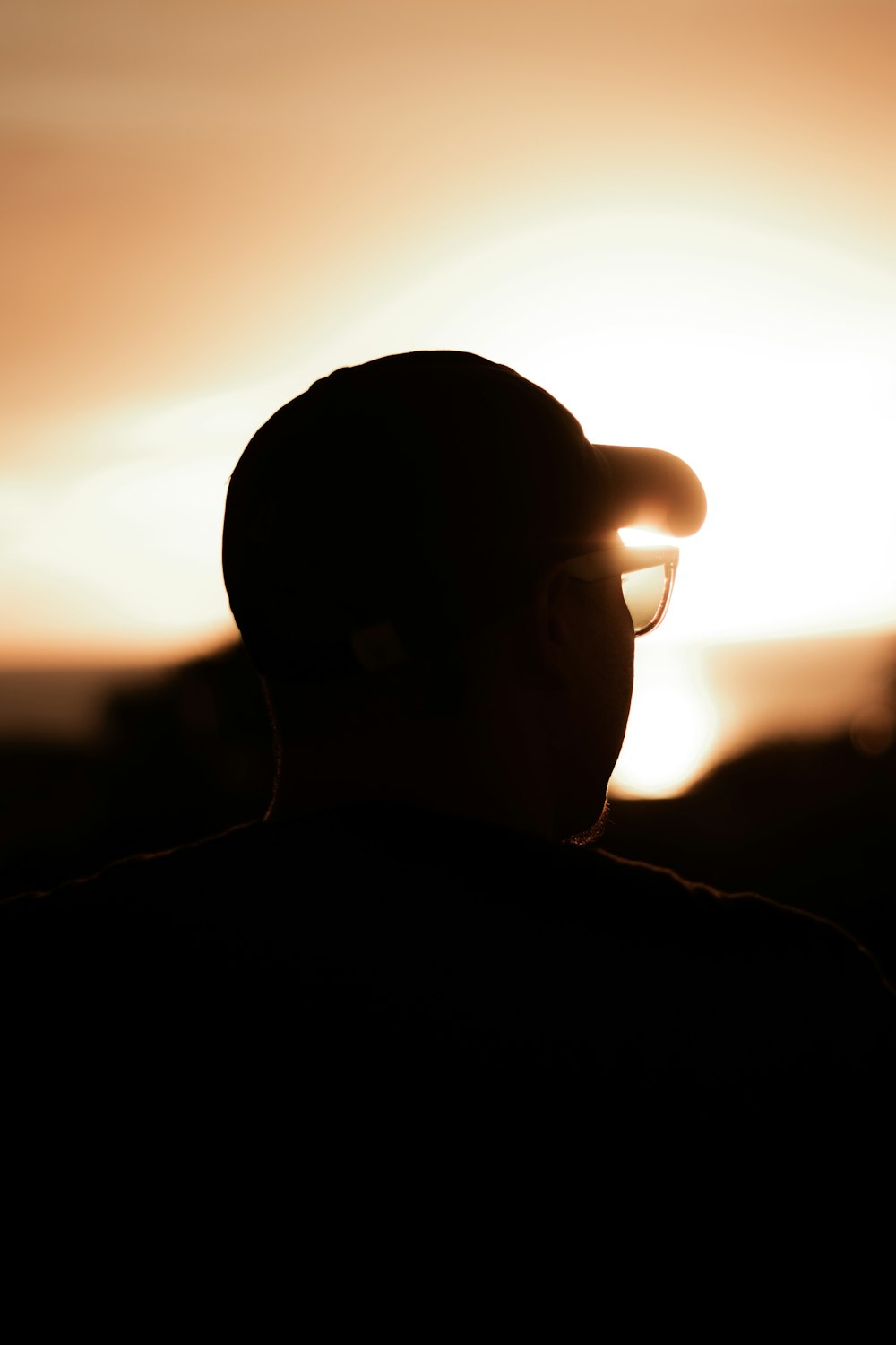 Silueta de hombre con gafas de sol durante la puesta del sol