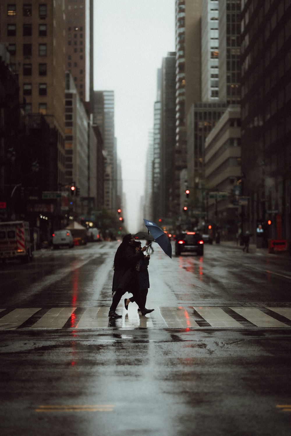 person in black jacket holding umbrella walking on pedestrian lane during daytime