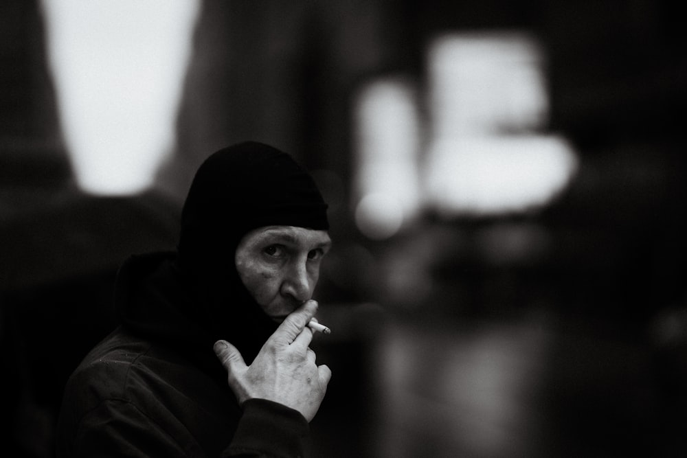 man in black knit cap smoking cigarette