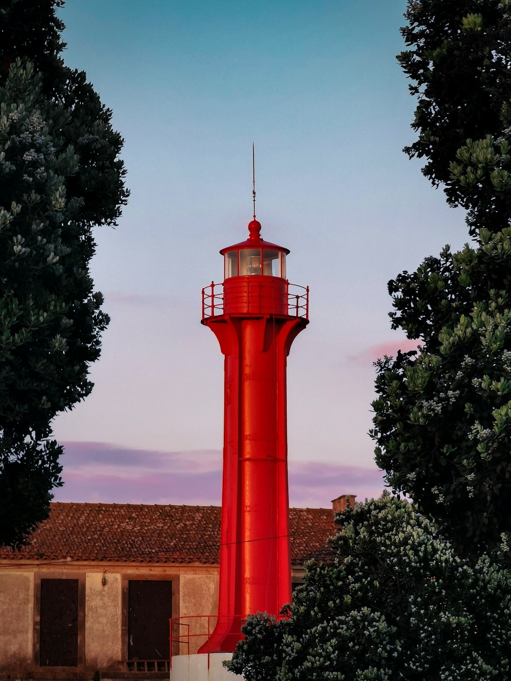 red and white tower near green trees during daytime