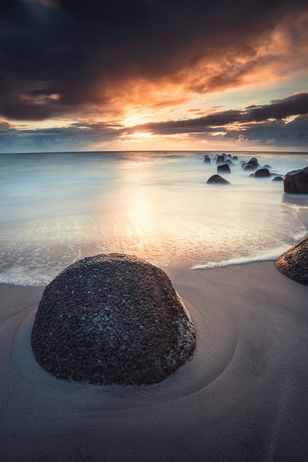 brown rock formation on seashore during sunset