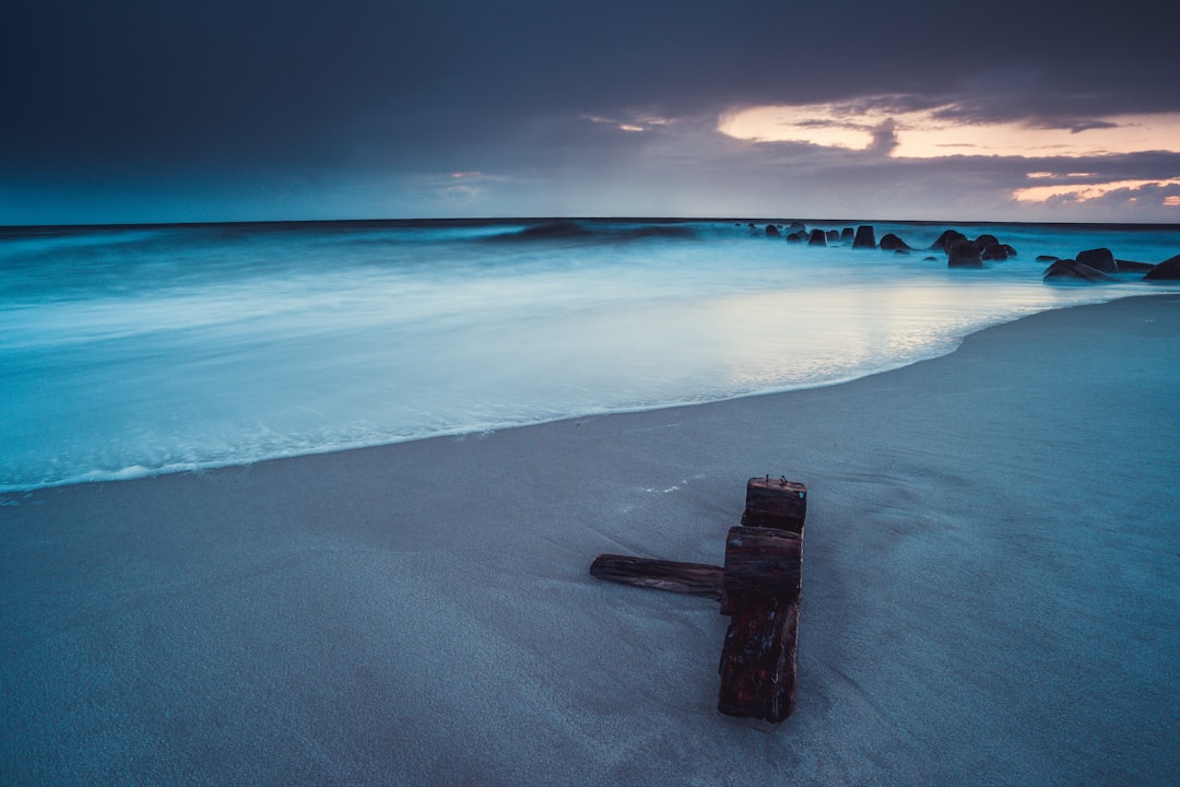 brown wooden cross on seashore during daytime