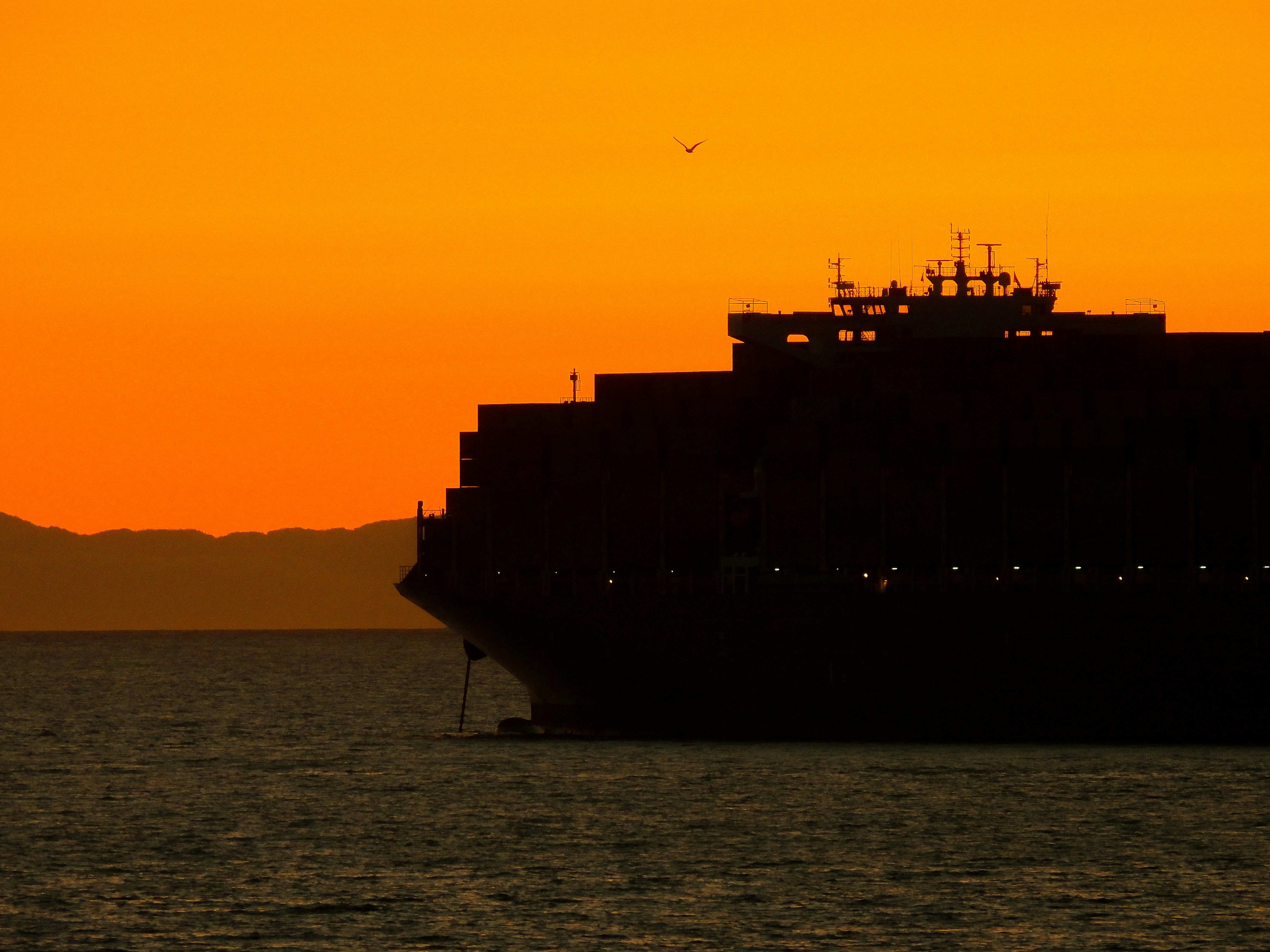CS Atlantic VLCC crude tanker silhouette against orange sunset sky on Atlantic Ocean