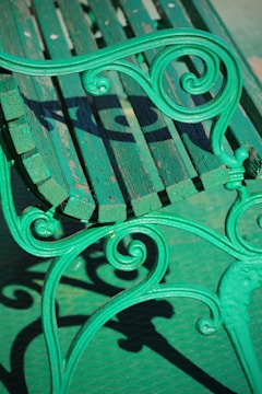 green metal bench on gray concrete floor