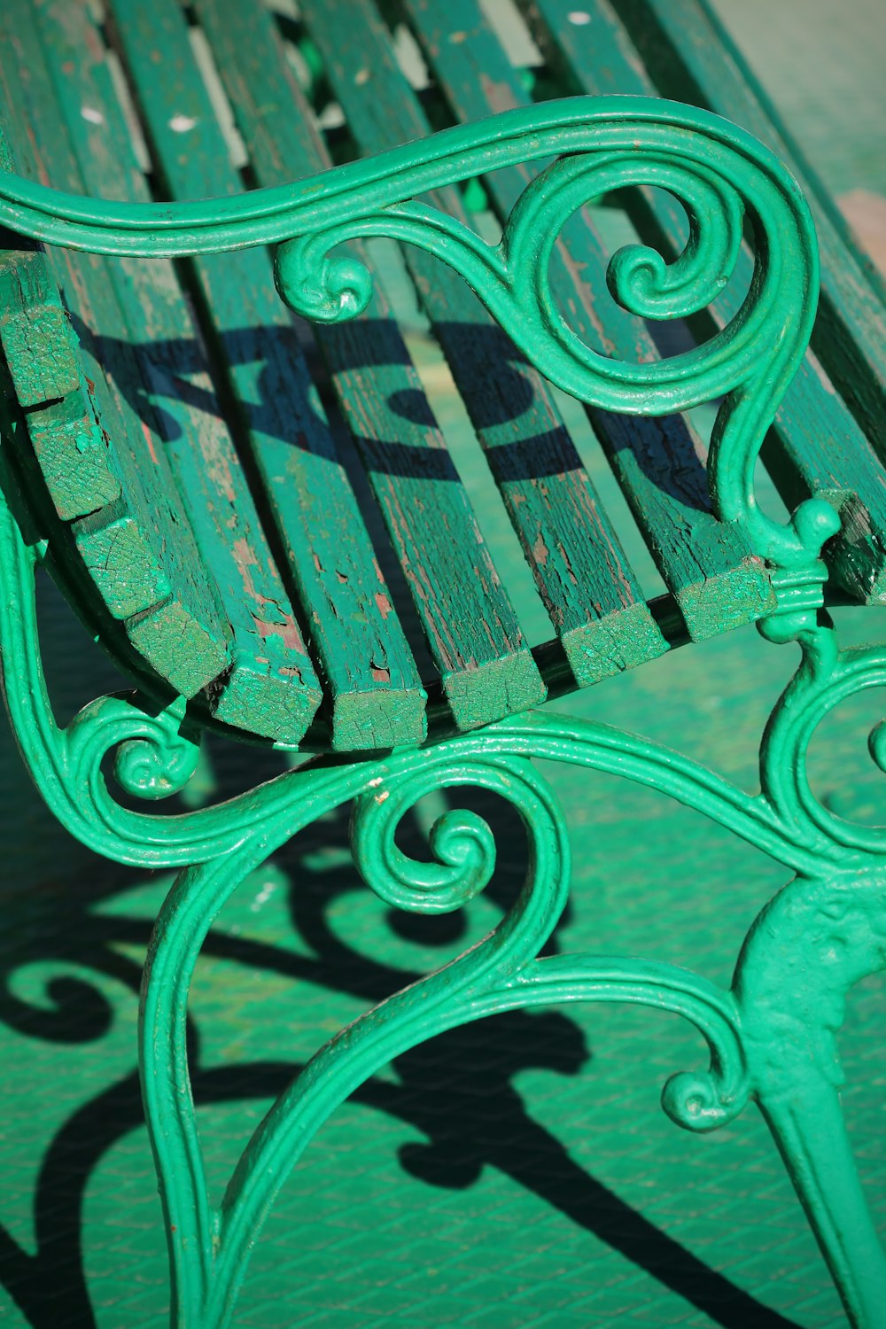 green metal bench on gray concrete floor