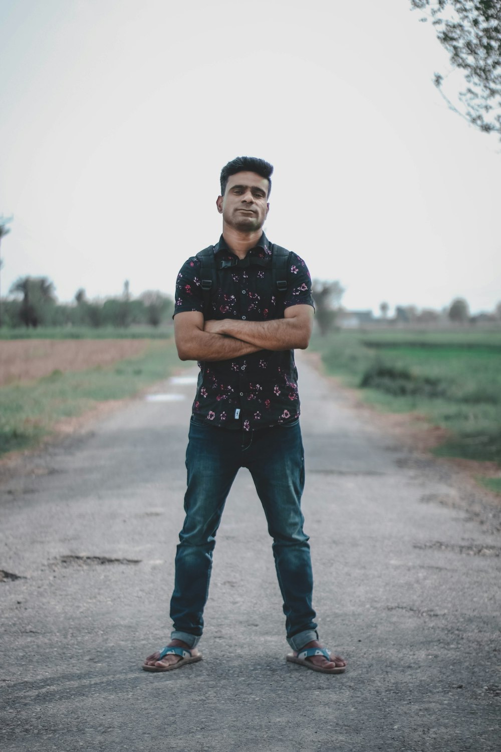 man in black crew neck t-shirt and black pants standing on gray asphalt road during