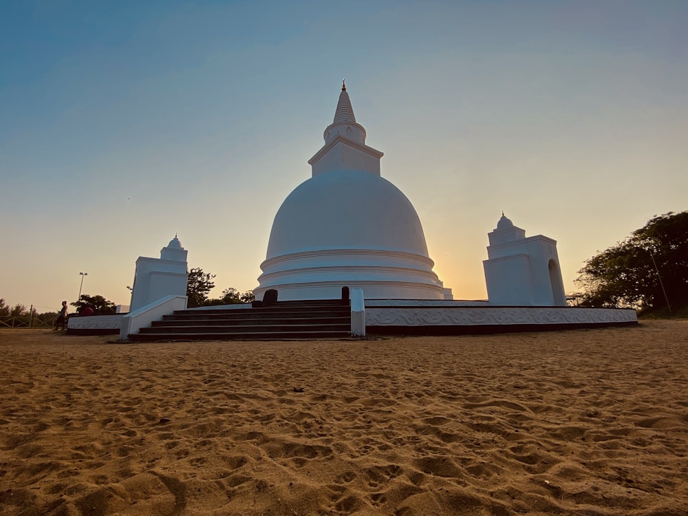 white concrete building on brown sand during daytime