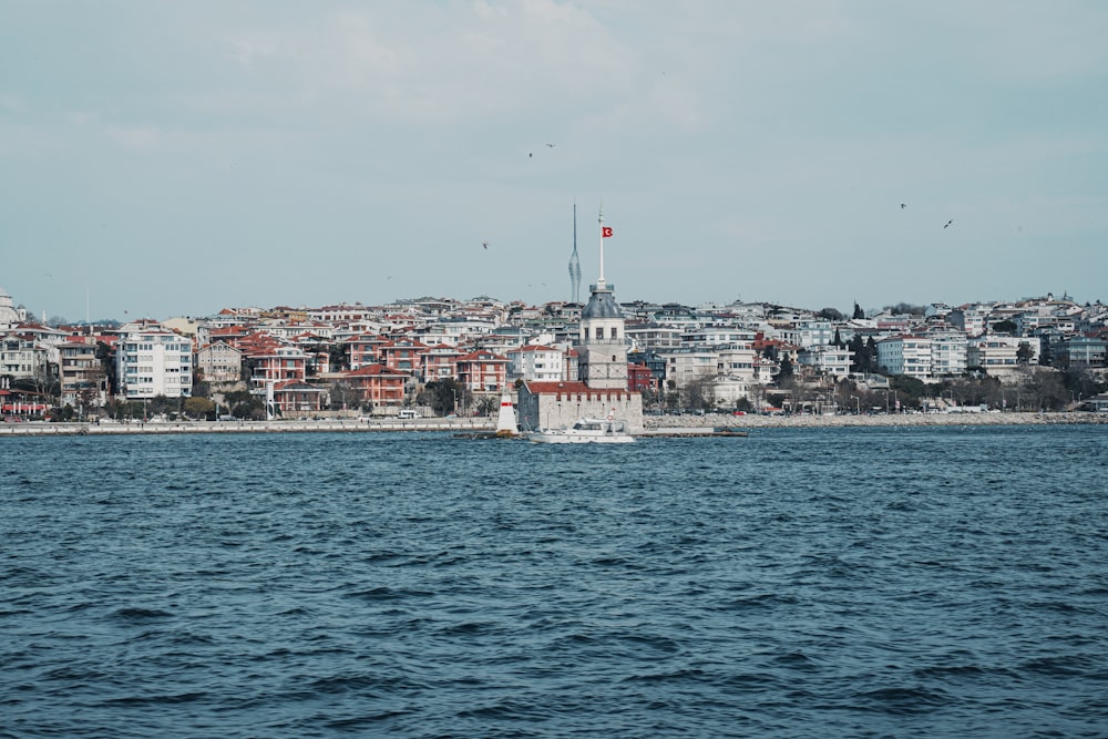 white boat on sea near city buildings during daytime