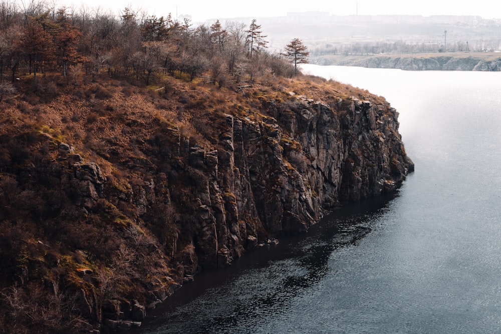 brown and green cliff near body of water during daytime